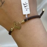 دستبند با بند بافت قهوه‌ای طرح رد پا با طلای ۱۸ عیار و وزن ۰.۲۲ گرم